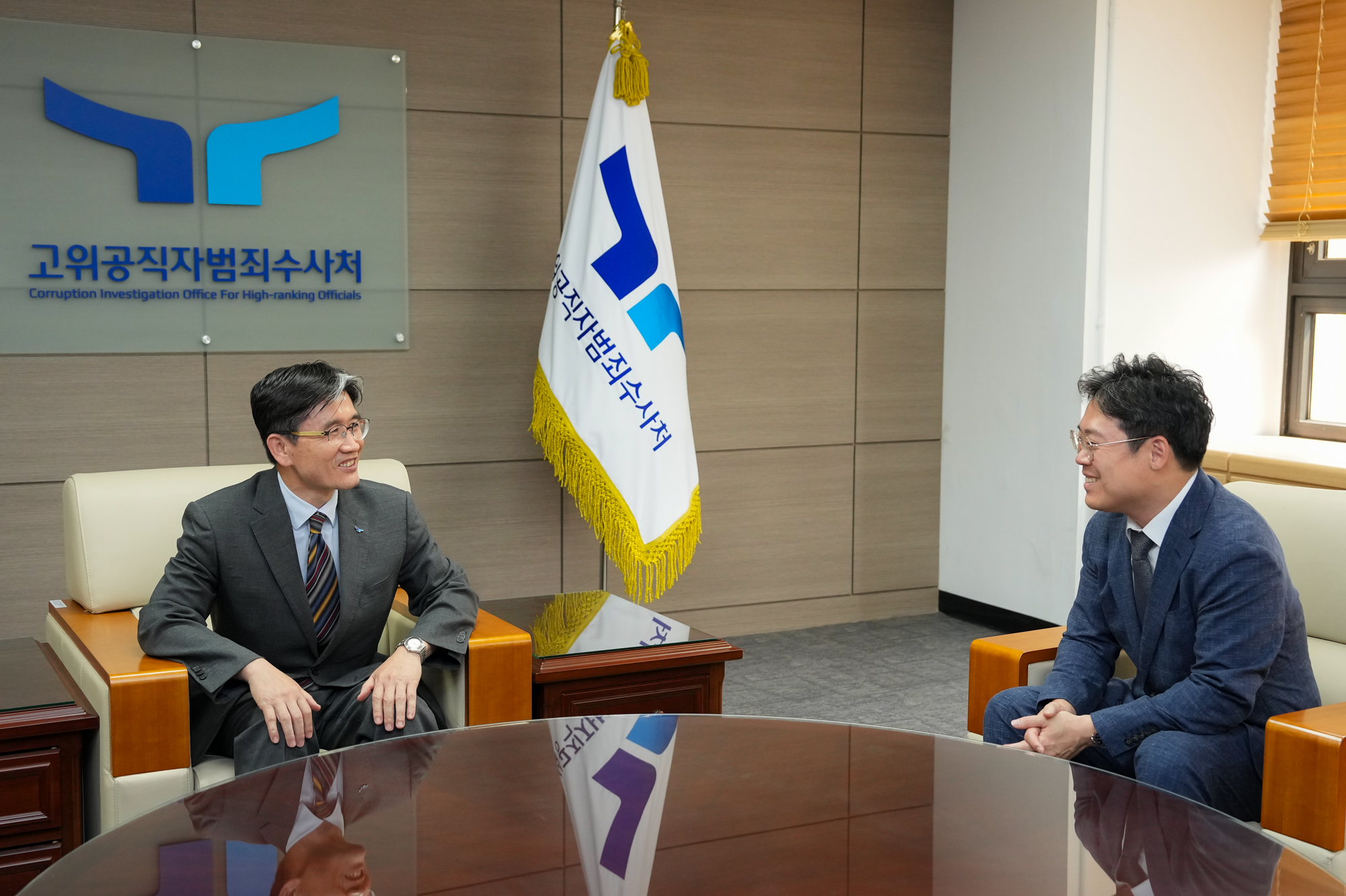 김정욱 회장과 오동운 처장이 원형 테이블에 앉아 대화를 나누고 있는 모습