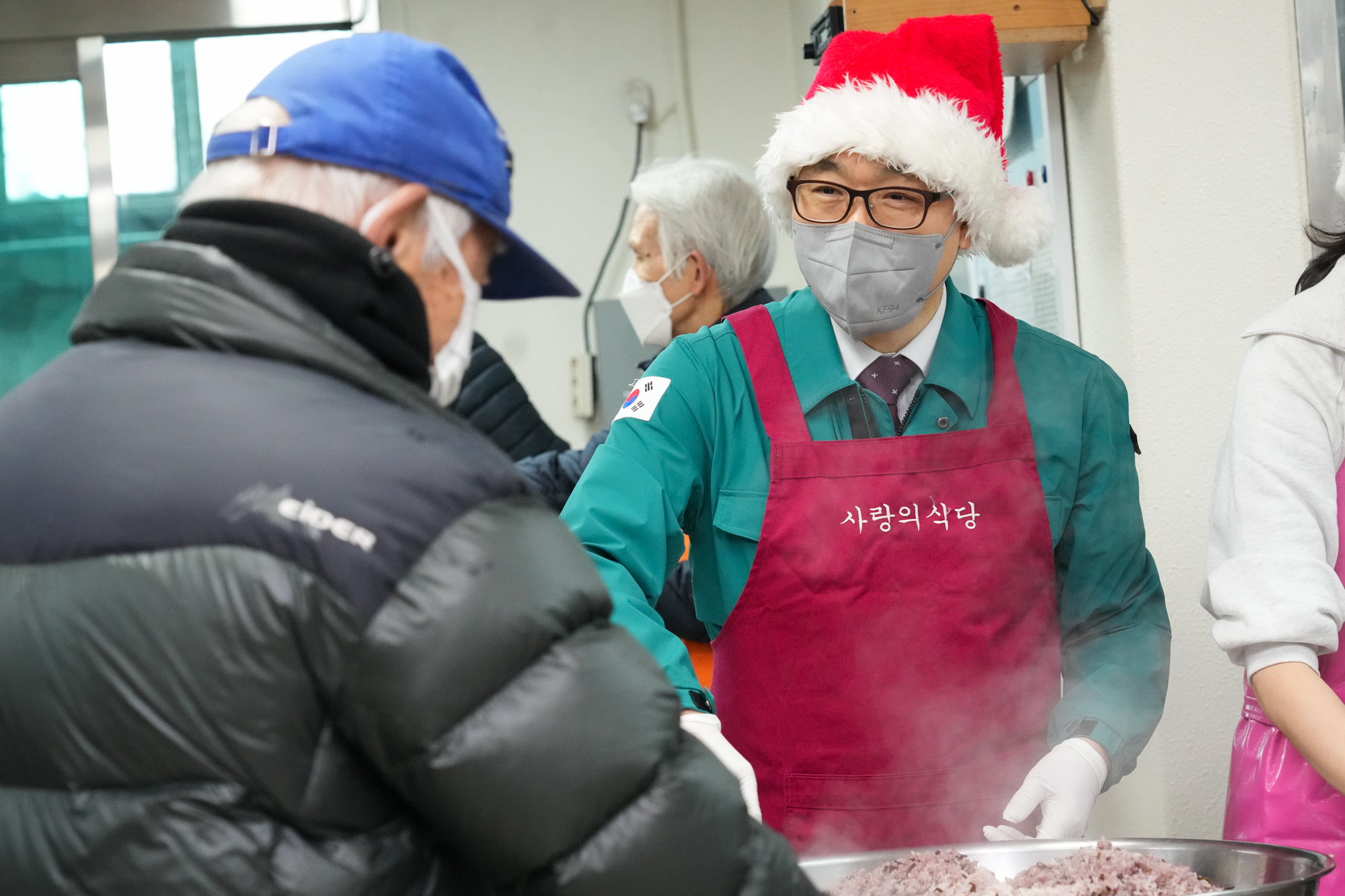 김진욱 처장이 사랑의 식당 옷을 입고 음식을 나눠주고 있는 모습
